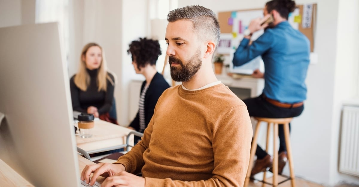 A professional man works at a desk in a modern office setting