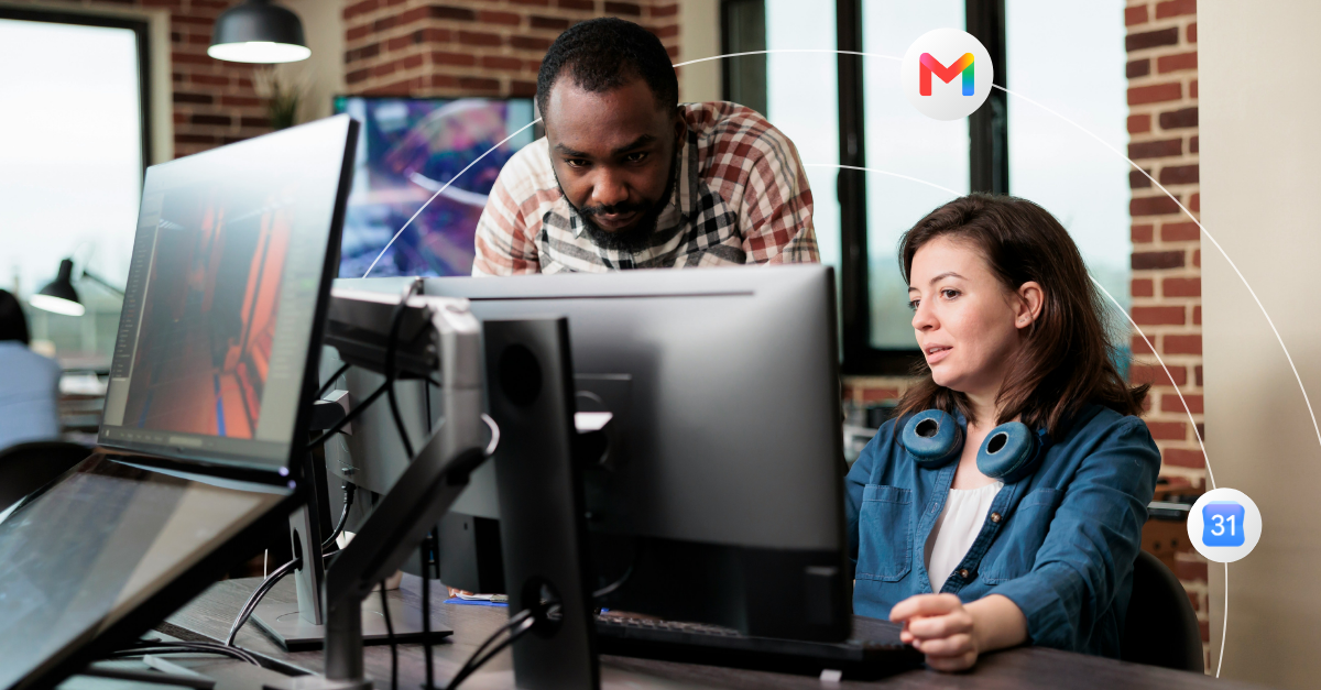Two office workers looking at the same desktop monitor 