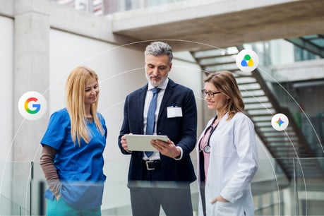 Three healthcare professionals talk in a modern office setting