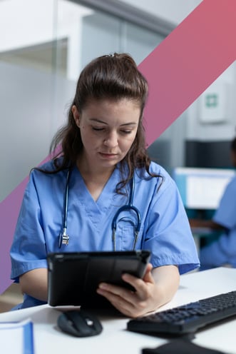 A nurse looks down at a tablet screen in a doctor's office.