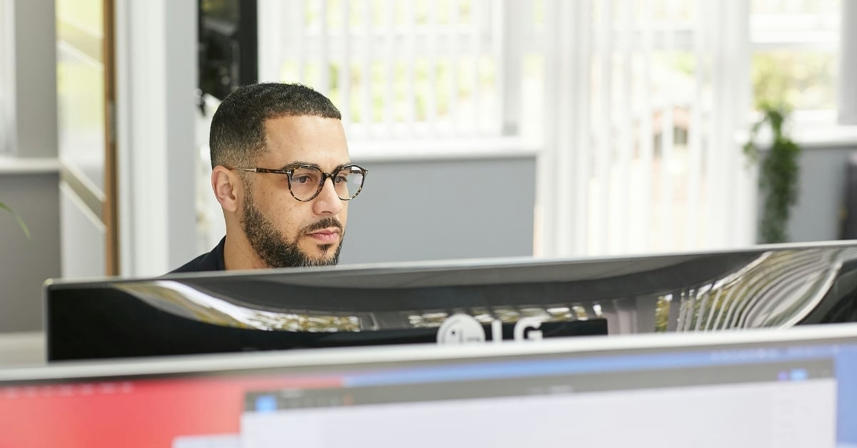 A professional office worker reads from his desktop monitor 