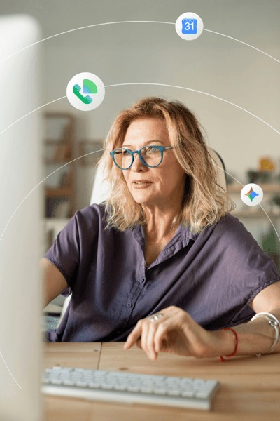 An professional-looking woman in teal glasses looks at a computer screen